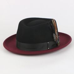 Introducing the Broadway Fedora, a masterclass in unique sophistication. Distinguished by its diamond-shaped crown, this hat makes a bold statement with its one-of-a-kind design. The contrasting crown and brim create a striking visual impact, while the matching removable feathers add an element of customization and flair. Perfect for those who seek to stand out with a touch of classic elegance, the Broadway Fedora effortlessly combines high fashion with distinctive style. Brim: 2 3/4th “(Snap Br Elegant Black Fedora With Flat Crown, Elegant Black Hat With Flat Crown, Classic Red Felt Hat For Formal Occasions, Red Adjustable Felt Hat For Formal Occasions, Classic Red Formal Felt Hat, Adjustable Red Felt Hat For Formal Occasions, Formal Black Adjustable Hat Bands, Black Flat Crown Felt Hat For Formal Occasions, Black Felt Hat With Flat Crown For Formal Occasion