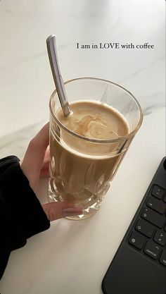 someone is holding a glass of coffee with a spoon in it and the caption reads, i am in love with coffee