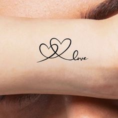 a person's arm with a tattoo on it that says love and two hearts