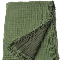 a green blanket with fringes on it