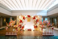 a decorated stage set up with flowers and candles for a wedding or special event in an indoor setting