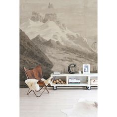 a chair and table in front of a wall with a mountain scene painted on it