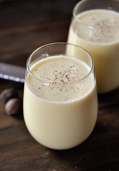 two glasses filled with milk sitting on top of a table