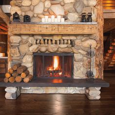 a stone fireplace with logs and candles on it