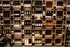 many bottles of wine are on shelves in a room that is filled with wooden crates