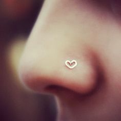 a nose piercing with a heart on it