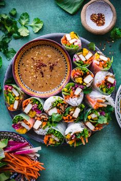 a platter filled with lots of food on top of a green table next to bowls