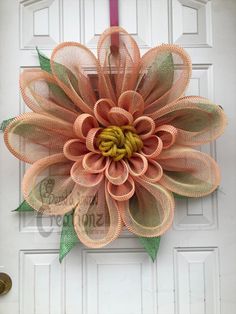 an orange mesh flower hanging on the front door