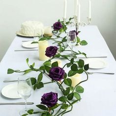 the table is set with white and purple flowers, candles, and wineglasses