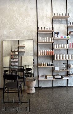 an empty room with several shelves and chairs in front of the wall filled with bottles