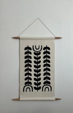 a white wall hanging with black designs on it