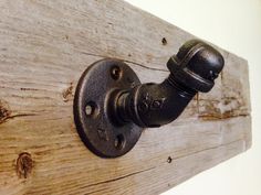 an old fashioned faucet is mounted to a wood plank wall with metal fittings