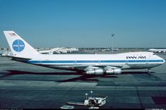 an airplane sitting on the tarmac at an airport with other planes in the background