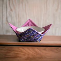 an origami bowl sitting on top of a wooden table