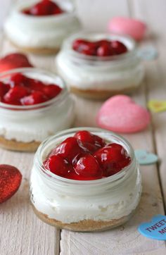 strawberry cheesecakes in small jars on a table