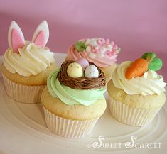 three cupcakes decorated with easter decorations on a plate