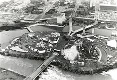 black and white photo of an aerial view of a city with bridges, buildings, and water