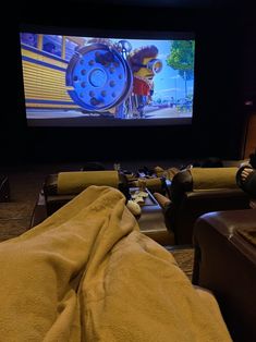 a person laying on a couch in front of a screen with the movie behind them