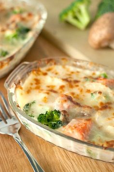 a casserole dish with broccoli and cheese in it on a wooden table