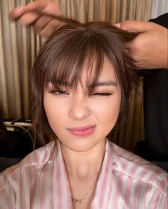 a woman getting her hair styled by someone