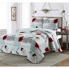 a bed covered in a blue and red comforter with poinsettis on it