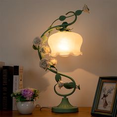 a lamp that is sitting on top of a table next to a potted plant