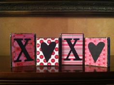 the word love spelled out with hearts on pink and red blocks in front of a fireplace