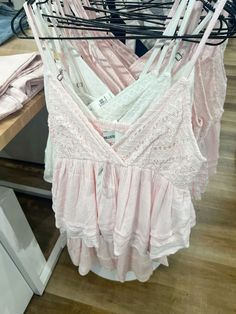 pink bras hanging on clothes rack in store