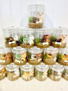 there are many small plastic jars with animals in them