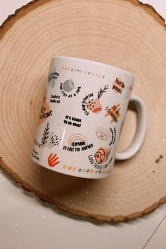 a white coffee cup sitting on top of a wooden slice