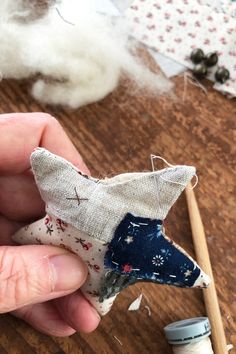 someone is stitching fabric on to a small animal ornament with scissors and thread