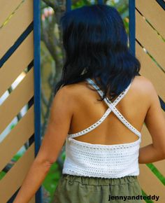 the back of a woman's white top with crochet on her shoulders