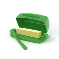 a green box with a piece of cheese in it and two spoons next to it