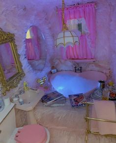 a pink bathroom with gold accents and white fur around the bathtub, sink, mirror and toilet