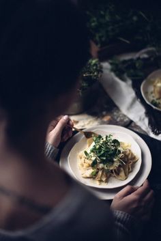 a person sitting at a table with plates of food