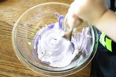 a person mixing white and purple food in a bowl