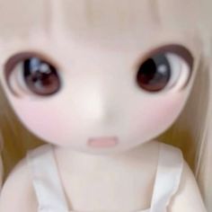 the doll is wearing a white dress and brown eyes