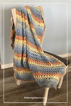 a crocheted blanket sitting on top of a wooden chair