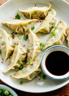 some dumplings are on a plate with dipping sauce