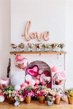 a fireplace with balloons and flowers on it in front of a sign that says love