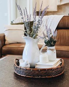 two vases filled with flowers sitting on top of a table next to a couch