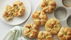 several small pies and muffin tins on a white table with green napkin