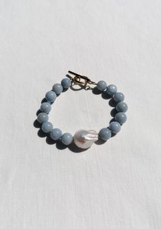 Angelite beads of sky blue colour, big white baroque pearl and toggle caslp - all hand knotted with 100% silk Lenght: 20,5 cm = 8" - the bracelet is chunky, this size is suitable for wrist 17 - 18 cm in circuit = 6.7"- 7" Metal - Tarnish resistant, made from PVD gold plated stainless steel - sweatproof/ waterproof gold plating, you can wear your jewelry every day and it will remains gold You will recieve your jewelry nicely packed in our brand box - ready to be gifted or to be stored in Blue Gemstone Bracelet, Silk Jewelry, Freshwater Pearl Jewelry, Bar Bracelet, Bar Bracelets, Blue Gemstones, Toggle Clasp, Baroque Pearls, Gemstone Bracelet