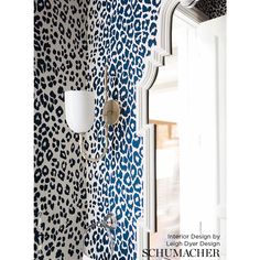 a bathroom with blue and white animal print wallpaper on the walls next to a mirror