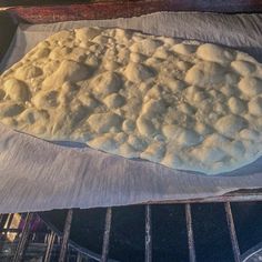 an uncooked pizza sitting on top of a baking sheet in the oven, ready to go into the oven