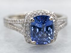 an oval shaped blue sapphire surrounded by pave diamonds