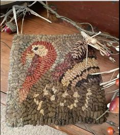 a close up of a rug on the floor with pine cones and other items around it