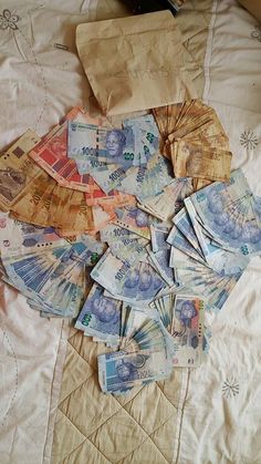 a pile of money sitting on top of a bed