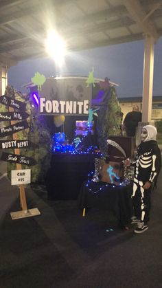 two people dressed up in costumes standing next to a sign that says fortnite