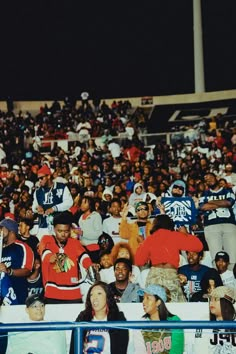 a group of people sitting in the stands at a football game